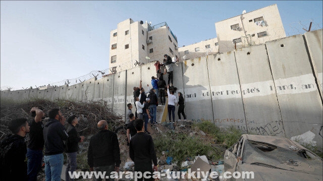 فلسطينيون يتسلقون جدار الفصل الإسرائيلي للوصول للأقصى